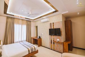 a hotel room with a bed and a tv at Bedi's Dream Land Hotel & Resort in Ayodhya
