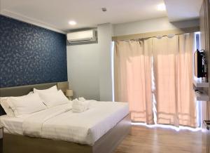 a bedroom with a large white bed with a window at ECL Travellers Inn in Nabas