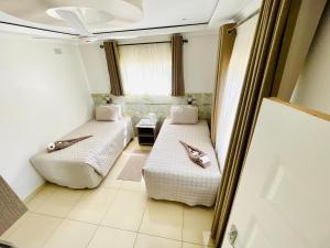 a room with two beds and a window at Sky Apartments in Harare +20 photos