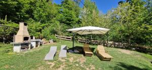 a group of benches and an umbrella in a yard at Baita al sole in Faida +10 photos