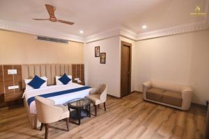 a bedroom with a bed and chairs and a couch at Bedi's Dream Land Hotel & Resort in Ayodhya