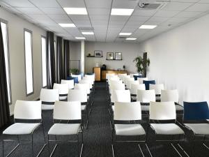 an empty room with white chairs in an office at Mercure Lyon Genas Eurexpo in Genas +118 photos