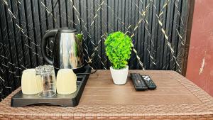 a table with a coffee maker and a plant on it at Elite Boutique Stays in Ujjain