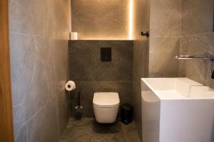a bathroom with a white toilet and a sink at Lofft Hotel in Ciechanów