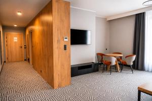 a room with a table and chairs and a tv at Lofft Hotel in Ciechanów