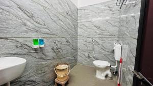 a bathroom with a toilet and a sink at Elite Boutique Stays in Ujjain +26 photos