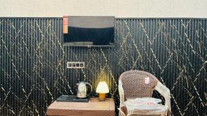 a table and a chair next to a table with a lamp at Elite Boutique Stays in Ujjain