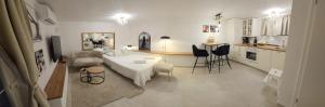 a living room with a bed and a kitchen at Luni Studio Apartment with garden in Kaštela