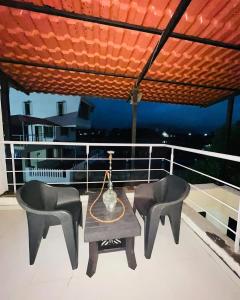 a table and two chairs on the deck of a boat at Paradise Villa in Lonavala