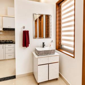 a bathroom with a sink and a mirror at The Crown Resort in Sonīpat