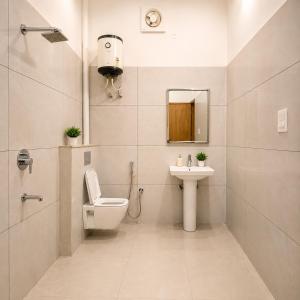 a bathroom with a toilet and a sink at The Crown Resort in Sonīpat