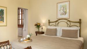 a bedroom with a bed and a table with flowers at VILLA LA MONARCA 16, Emma Villas in Torrita di Siena