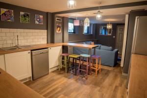 a kitchen with a counter and stools in a room at Bronze Room with Shared Bathroom, Leeds City Centre - Mary Morris For Students and Young Professionals in Leeds