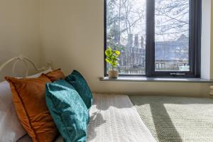 a bedroom with a bed with pillows and a window at Bronze Room with Shared Bathroom, Leeds City Centre - Mary Morris For Students and Young Professionals in Leeds