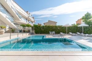 a swimming pool in front of a building at Apartamento las palmeras 2 Planta 3 in Cala Millor