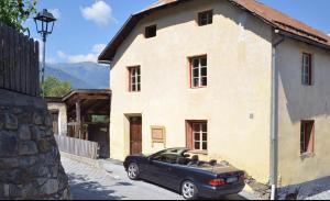 a black car parked in front of a house at SOMMERFRISCHE TSCHENGLS Ein ganzes historisches Ferienhaus für euch in SÜDTIROL Urlaub im ruhigen Bergdorf Tschengls im Vinschgau mit Weitblick und Gartenterrasse ideal für Kleingruppen Familien mit Hund Besonders empfehlenswert im FRÜHLING und HERBST in Lasa