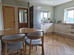 a kitchen with a wooden table and a refrigerator at Thorn Tree Cottage in Hope