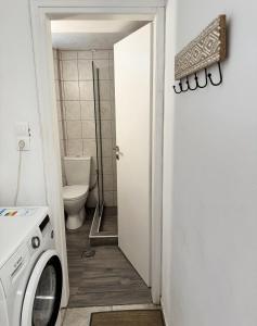 a bathroom with a toilet and a washing machine at Polymnia's apartment in Matala