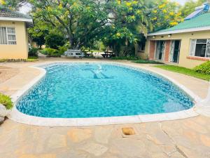 a swimming pool in a yard with a house at Sky Apartments in Harare