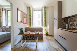 a small living room with a table and a couch at Casa DiMì - 2 BR, 2 en-suite bath, 2 min M5, Smart lock in Milan +36 photos