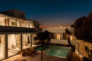 a house with a swimming pool at night at Meros, Santikos Collection in Naousa
