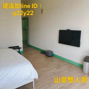 a bedroom with a bed and a tv on a wall at Summer Homestay in Kenting