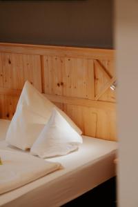 a bed with white sheets and pillows on it at Almhof Lässer in Balderschwang