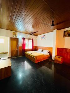 a large bedroom with a bed and a wooden ceiling at Oval Retreat in Cochin