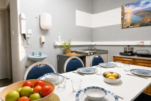 a kitchen with a table with a bowl of fruit on it at Sefranda Guesthouse in San Ġwann