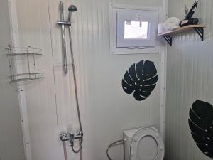 a white bathroom with a toilet and a window at Bungalows Rea in Burgas