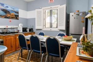 a kitchen with a table and chairs and a refrigerator at Sefranda Guesthouse in San Ġwann