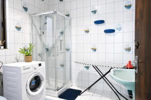 a bathroom with a shower and a washing machine at Sefranda Guesthouse in San Ġwann