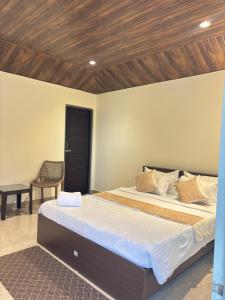 a bedroom with a large bed with a wooden ceiling at The Hillshade villa in Borpāni