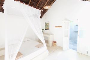a room with white walls and a bed with curtains at The Rascals Kite Resort in Kalpitiya