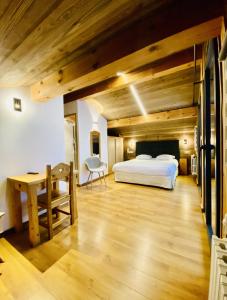a bedroom with a bed and a desk in a room at Hotel Alpina in Morzine