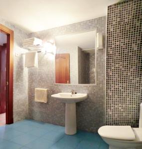 a bathroom with a sink and a toilet and a mirror at Apartamento Huelin in Málaga