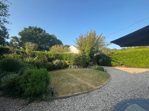 a garden with a small yard with a gravel driveway at Cotford Cottage in Sidmouth
