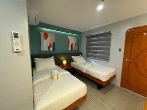 a hotel room with two beds and a window at ECL Travellers Inn in Nabas