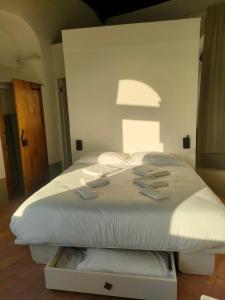 ein großes weißes Bett in einem Zimmer mit Fenster in der Unterkunft Torre Subrosa, vasca in camera cromoterapia in Viterbo