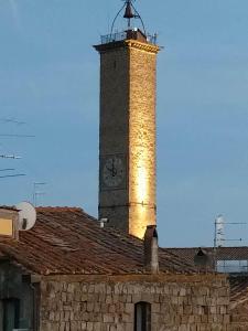 ein Uhrturm auf einem Steingebäude in der Unterkunft Torre Subrosa, vasca in camera cromoterapia in Viterbo