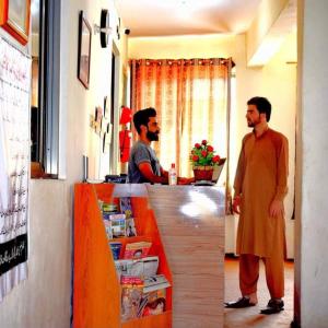 two men standing at a counter in a store at Yasin Holiday Hotel in Gilgit +9 photos
