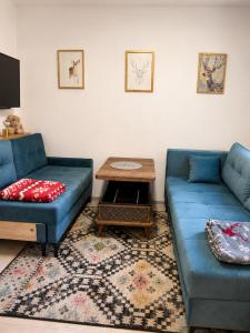 a living room with two blue couches and a table at KOTA - Prime Location in Jahorina