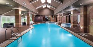 a large pool with blue water in a building at voco St. Johns Solihull by IHG in Solihull