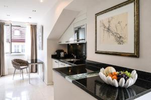 a kitchen with a bowl of fruit on a counter at VISIONAPARTMENTS Freyastrasse - self check-in in Zurich