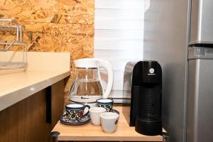 a coffee maker and cups on a table in a kitchen at השקט של כליל - בקתה קסומה בטבע עם בריכה פרטית in Clil
