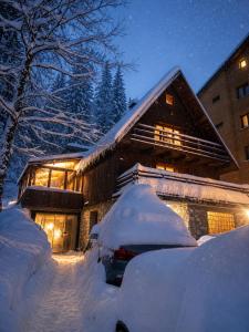 a snow covered house with a car parked in the snow at KOTA - Prime Location in Jahorina