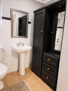 a bathroom with a black cabinet and a sink at Tree Aloe Guest House in Mokopane +63 photos