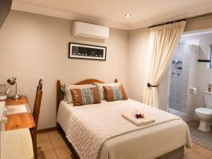 a bedroom with a bed and a bathroom with a shower at Tree Aloe Guest House in Mokopane
