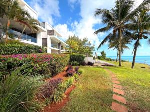 a house with a garden and a brick path at Beachfront Penthouse - Panoramic Ocean View in Cap Malheureux