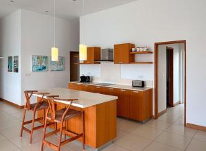 a kitchen with wooden cabinets and a table and chairs at Beachfront Penthouse - Panoramic Ocean View in Cap Malheureux